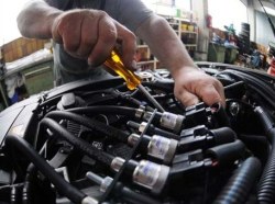 Mechaniker mit Werkzeug arbeitet am PKW Motor